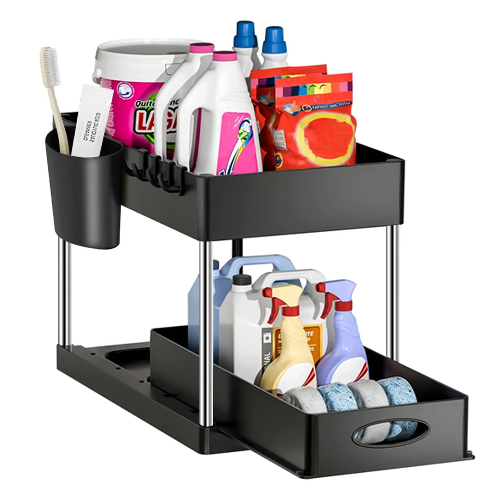 Zwart keukenrek met twee niveaus, uitschuifbare lade, ophanghaken en zijvakje voor extra opbergruimte, gevuld met schoonmaakproducten zoals sprays, schuursponsjes, tandenborstel en wasmiddelen. Ideaal voor een georganiseerde kast onder de gootsteen of in de badkamer.