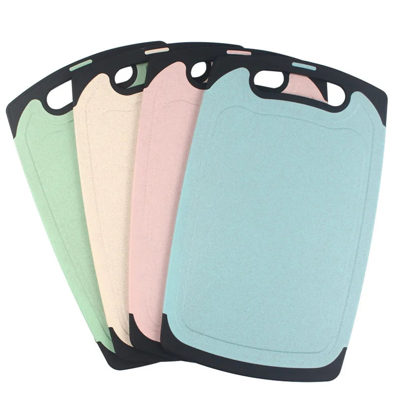 Set van vier kleurrijke kunststof snijplanken van DHProducts met handvatten, in groen, beige, roze en blauw, afgebeeld op een witte achtergrond.