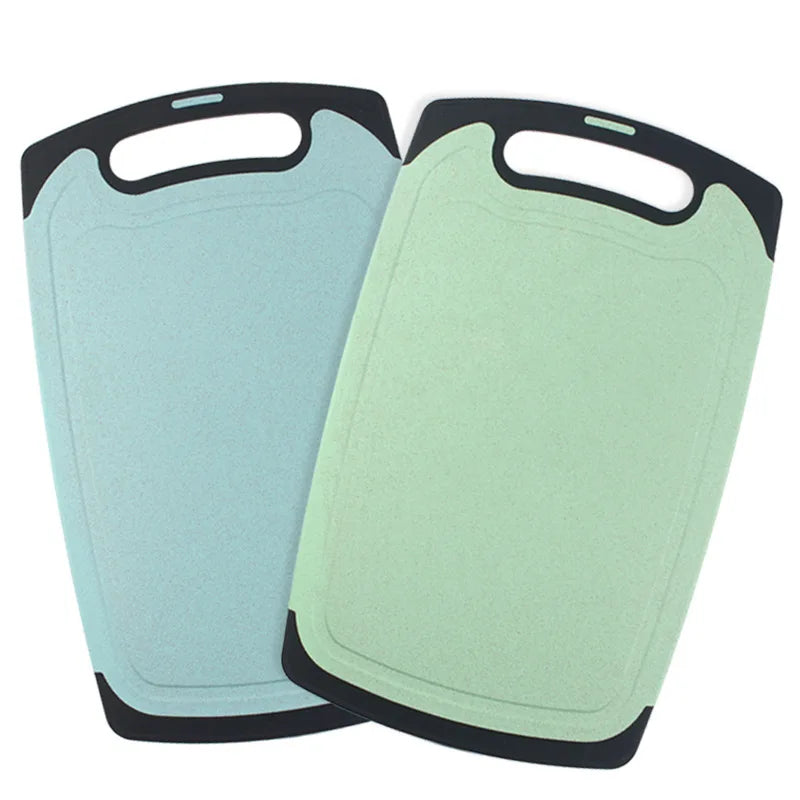 Set van twee kunststof snijplanken van DHProducts met ergonomische handgrepen, in zacht blauw en groen, afgebeeld op een witte achtergrond.