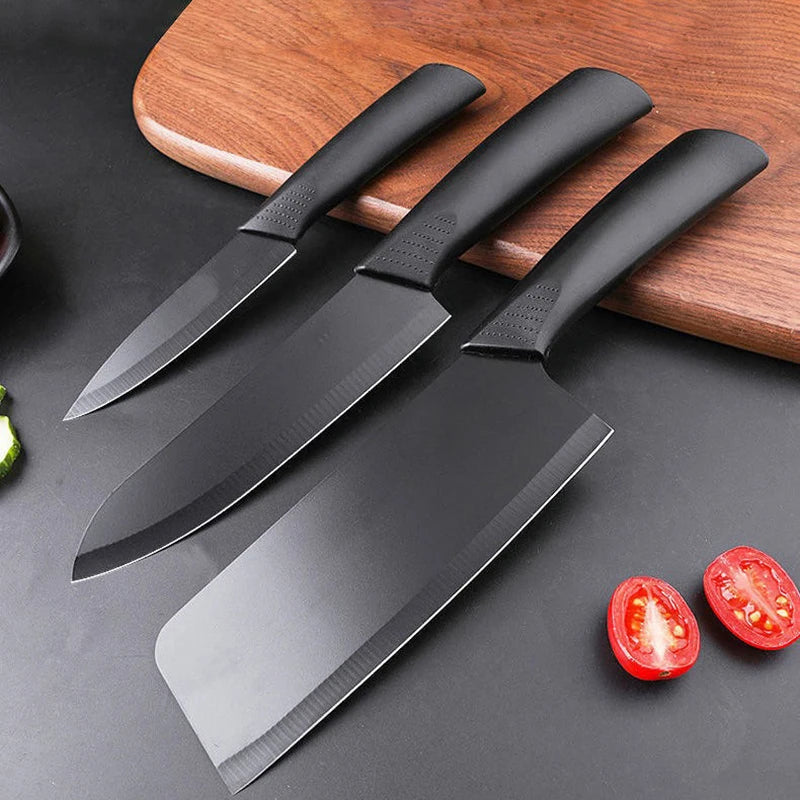 "DH Black Steel Kitchen Knives Set met drie zwarte keukenmessen op zwart werkblad en houten snijplank – modern en stijlvol design
