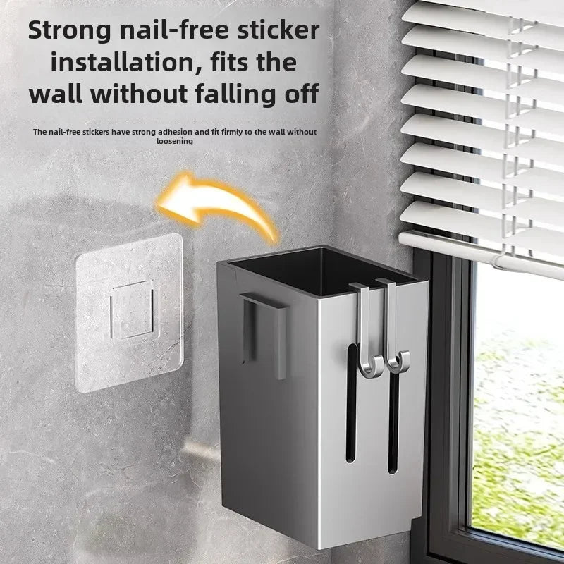 Een rechthoekige, metalen keukengerei-houder, bevestigd aan een grijze muur met een nagelvrije sticker, naast een raam met jaloezieën. Een pijl wijst van de sticker naar de houder om de installatie zonder boren te illustreren, en de tekst benadrukt de sterke kleefkracht.